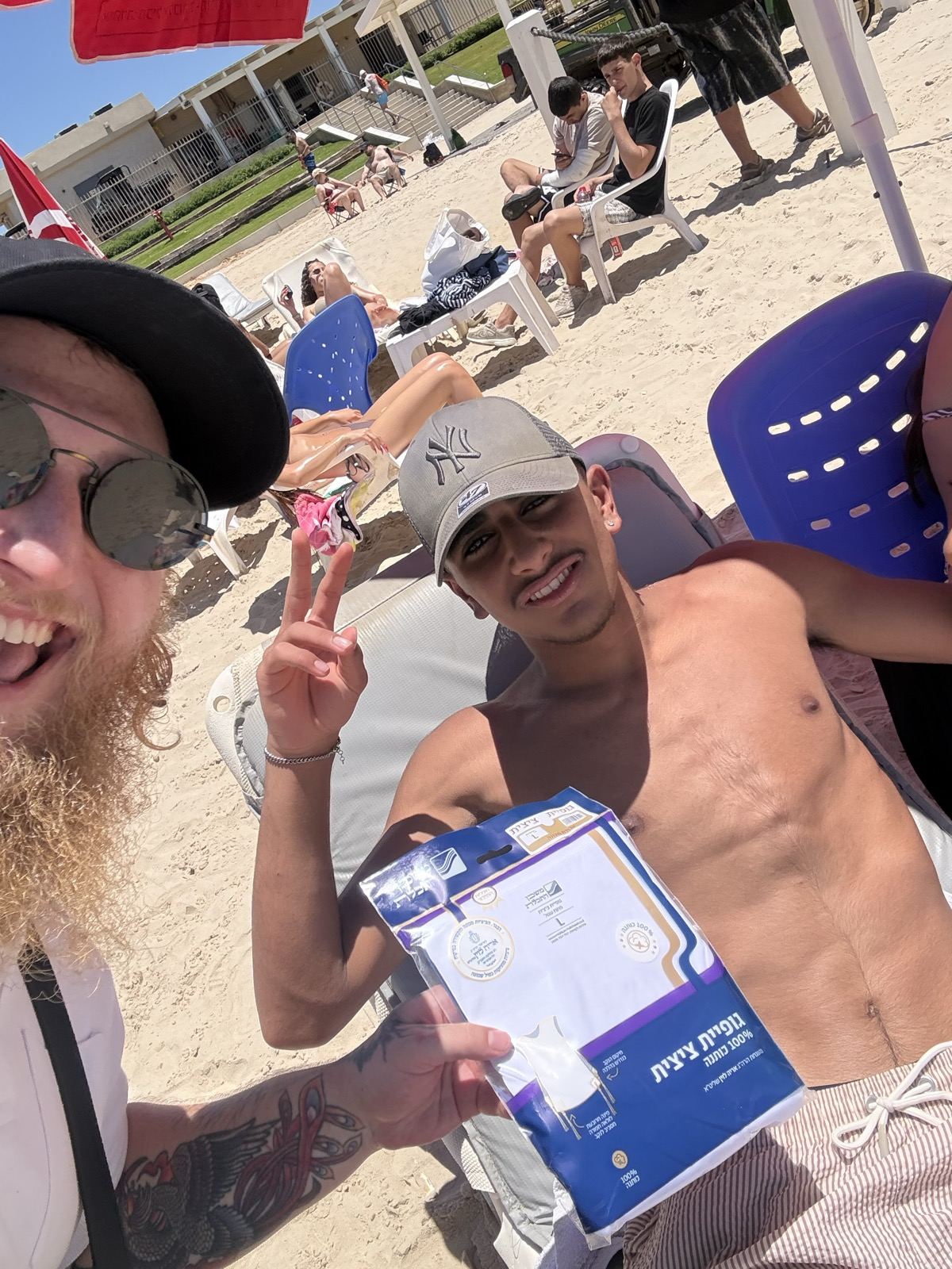 A smiling man on the beach holding a gift pack