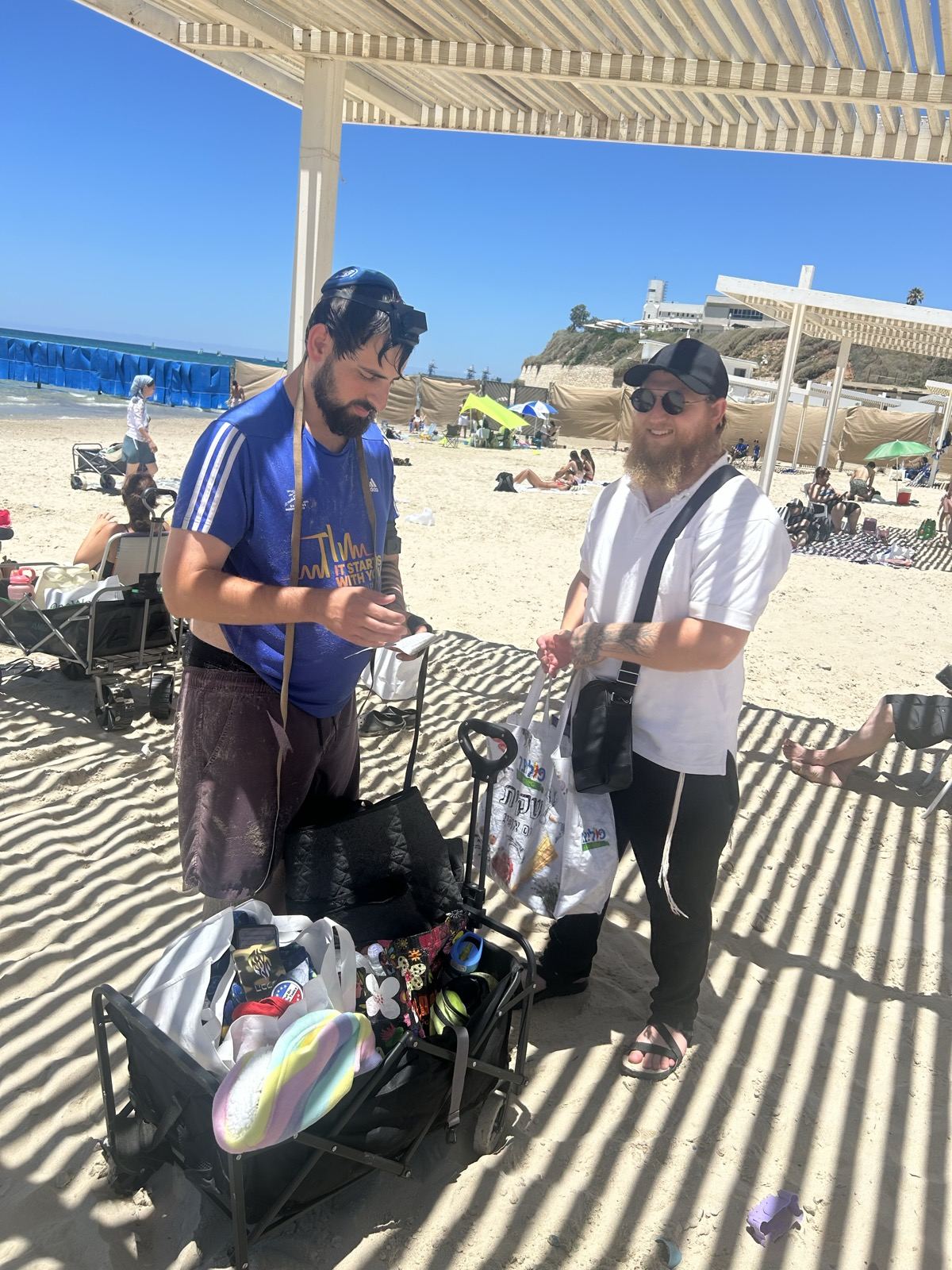 Two men at a mitzvah table on a sunny beach