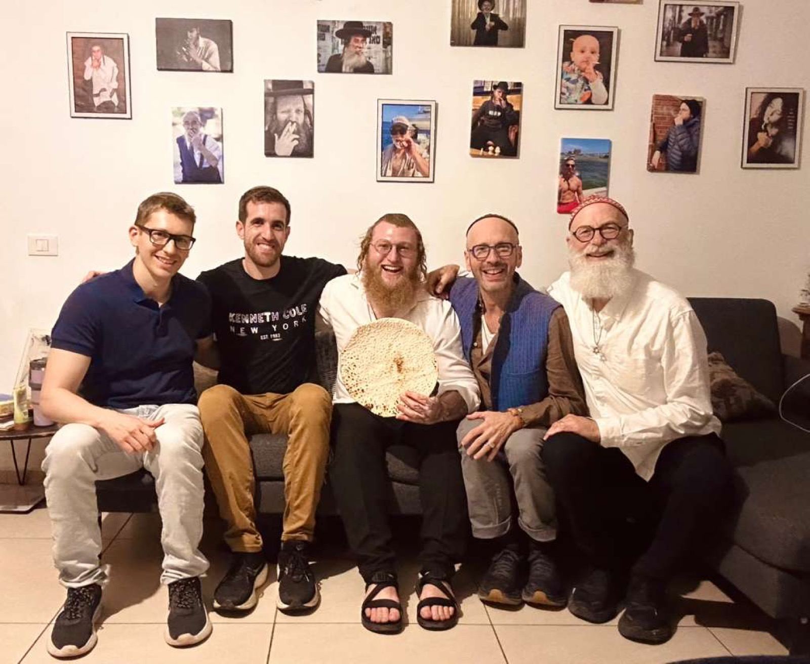 Friends sitting together on a couch holding a large round matzah
