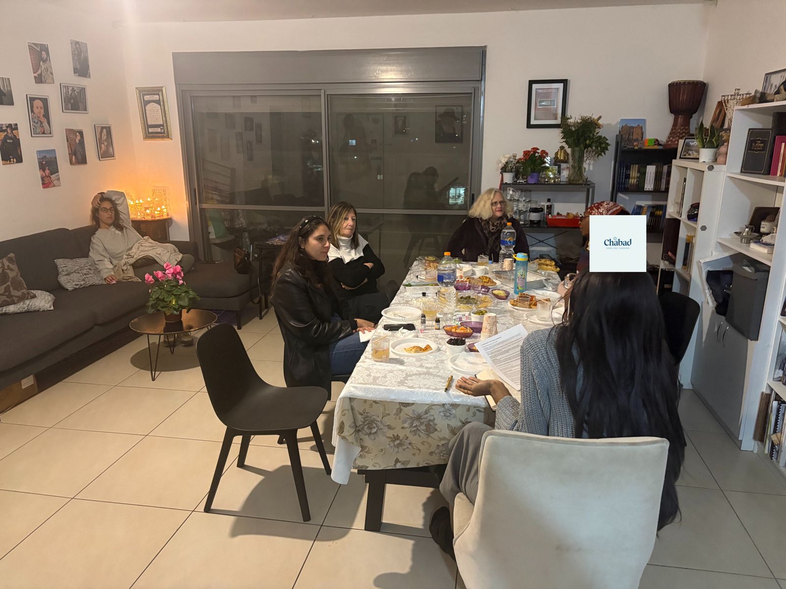 Women gathered around a long table for an evening together in Hadera